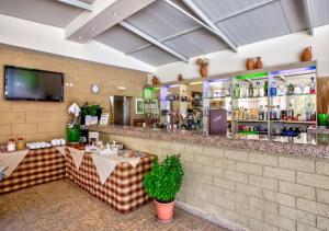 a restaurant with a bar with two tables and a tv at Paras Sun Hotel & Apartments in Ialysos