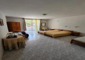 a large room with two beds and a table at Paras Sun Hotel & Apartments in Ialysos