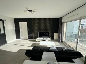 een woonkamer met een bank en een tv bij T3 proche aéroport in Saint-Jacques-de-la-Lande