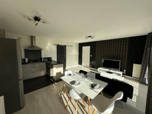 een keuken met een witte tafel en witte stoelen bij T3 proche aéroport in Saint-Jacques-de-la-Lande