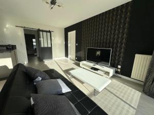 een woonkamer met een bank en een tv bij T3 proche aéroport in Saint-Jacques-de-la-Lande +5 foto's