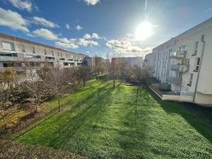 an apartment yard with a grassy yard next to a building at T3 proche aéroport in Saint-Jacques-de-la-Lande