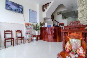 a living room with a fireplace and some chairs at Kim Hồng Anh Guest House in Phu Quoc