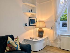 een woonkamer met een tafel met een lamp erop bij Elegant 2-Bed Flat in Shenfield in Mountnessing