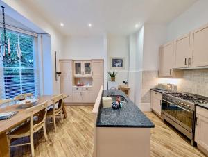 een keuken met een tafel en een aanrechtblad bij Elegant 2-Bed Flat in Shenfield in Mountnessing