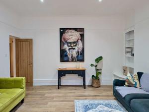een woonkamer met een bank en een schilderij aan de muur bij Elegant 2-Bed Flat in Shenfield in Mountnessing