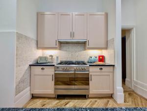 een keuken met witte kasten en een fornuis bij Elegant 2-Bed Flat in Shenfield in Mountnessing +22 foto's