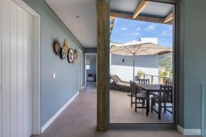 een eetkamer met een tafel en een paraplu bij Seagull View Sunset in Keurboomstrand