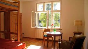 a living room with a table and a window at VILLA AM SEE - nähe Berlin in Biesenthal