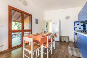 a kitchen with a table and chairs in a room at AffittaSardegna - Appartamenti Appentos in Capo Comino