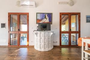 a living room with doors and a tv at AffittaSardegna - Appartamenti Appentos in Capo Comino