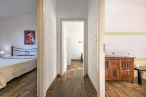 a bedroom with a bed and a dresser and a hallway at AffittaSardegna - Appartamenti Appentos in Capo Comino +28 photos