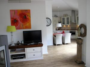 a living room with a television and a kitchen at Appartement Meeresrauschen in Baabe