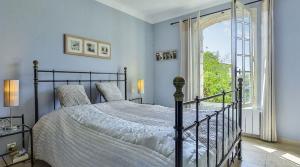 a bedroom with a bed and a large window at Charming villa - perfectly located in Roquefort-les-Pins