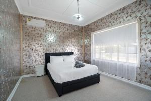 a bedroom with a bed and a window at Edwin Cottage Dubbo - close to the hospital in Dubbo