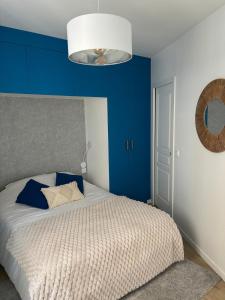 a bedroom with blue walls and a bed at Charming modern & bright apartment in Fontenay-sous-Bois