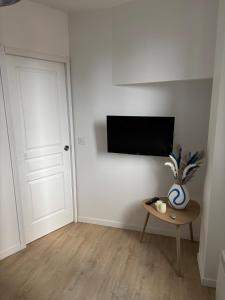 a room with a table and a tv on a wall at Charming modern & bright apartment in Fontenay-sous-Bois