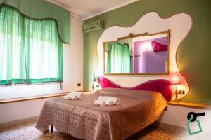 ein Schlafzimmer mit einem Bett mit einem großen Spiegel in der Unterkunft Hotiday Palermo Agostino in Palermo