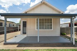 a house with a porch with a garage at Edwin Cottage Dubbo - close to the hospital in Dubbo