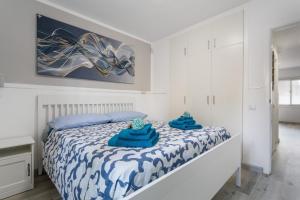 una camera da letto con un letto con asciugamani blu sopra di Horizon blu a Corralejo Altre 31 foto