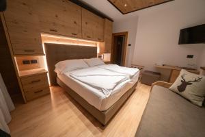 een slaapkamer met een groot wit bed in een kamer bij HOTEL FONTANA in Sappada