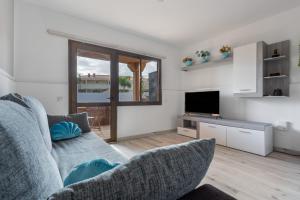 un soggiorno con un divano e una televisione di Horizon blu a Corralejo