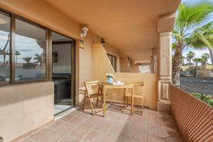 un patio con tavolo e sedie su un balcone di Horizon blu a Corralejo