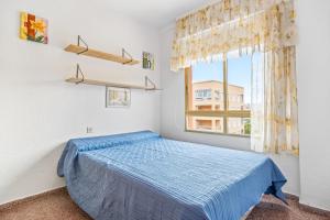 een slaapkamer met een blauw bed en een raam bij Nautico 3 in Santa Pola +14 foto's