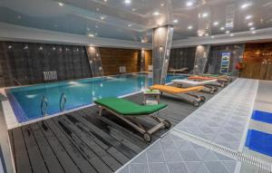 een zwembad met diverse ligstoelen en een zwembad bij New Gudauri Loft 2 in Goedaoeri