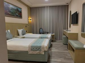 een hotelkamer met twee bedden en een bureau bij Afraa Hotel in Mekka +153 foto's