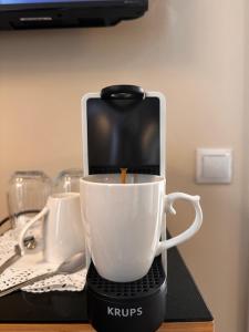 uma cafeteira com uma chávena branca sobre uma mesa em Maissance em Preveza