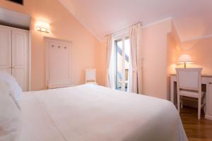 una camera da letto con un grande letto bianco e una finestra di Hotel Cenobio Dei Dogi a Camogli