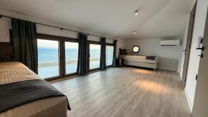 een slaapkamer met een bed en uitzicht op de oceaan bij Eosea Hemera in Ierissos +17 foto's