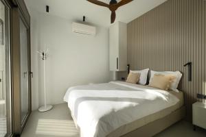 een slaapkamer met een groot bed met witte lakens bij Eosea Hemera in Ierissos