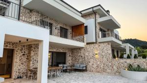 een gebouw met een terras met een tafel en stoelen bij Eosea Hemera in Ierissos