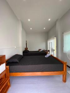 une chambre avec un grand lit dans une pièce dans l'établissement Phu Aunna, à Ko Phayam