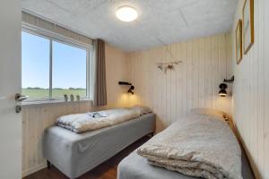 zwei Betten in einem Zimmer mit Fenster in der Unterkunft Villavilla 546 in Vester Lem