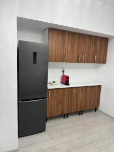 La cuisine est équipée d'un réfrigérateur et de placards en bois. dans l'établissement Apartament Modern Penthouse Rm Valcea, à Valcea 7 autres photos