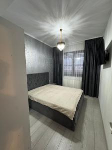une chambre avec un lit et un lustre dans l'établissement Apartament Modern Penthouse Rm Valcea, à Valcea