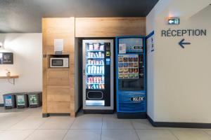 einen Kühlschrank und eine Soda-Maschine in einem Laden in der Unterkunft ibis budget Bayonne in Bayonne