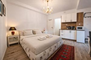 a bedroom with a large bed and a kitchen at Garden Studio with Kitchen & BBQ - KindStay Suites Prague Airport in Kněžívka