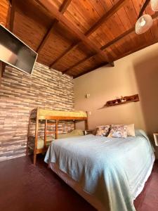 a bedroom with a bed and a brick wall at CABAÑAS MECHI in Mar del Plata
