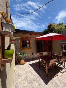 een patio met een houten tafel en een parasol bij CABAÑAS MECHI in Mar del Plata +60 foto's