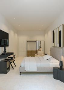 een grote slaapkamer met een groot bed en een bureau bij Fenici Levanzo Hotel - Adults Only in Levanzo