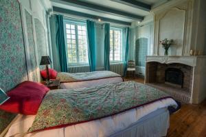 una camera da letto con due letti e un camino di La Bastide de Saint Martin a Saint-Martin-de-Ré