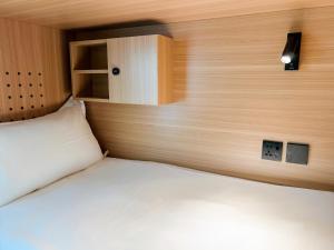 een slaapkamer met een bed met een houten hoofdeinde bij HOMIX Hotel in Singapore