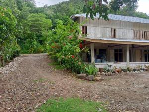 a house with a dirt road in front of it at Komachi House in Limbung