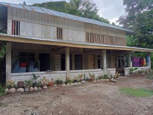 an old house with a lot of plants in front of it at Komachi House in Limbung
