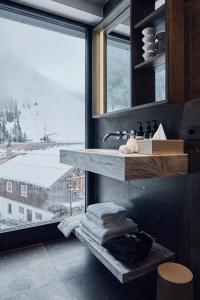 ein Badezimmer mit Waschbecken und großem Fenster in der Unterkunft Chalet Ischgl - Modern Luxury Residences in Ischgl