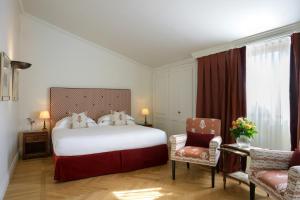 a bedroom with a large white bed and two chairs at Grand Hotel Continental Siena - Starhotels Collezione in Siena